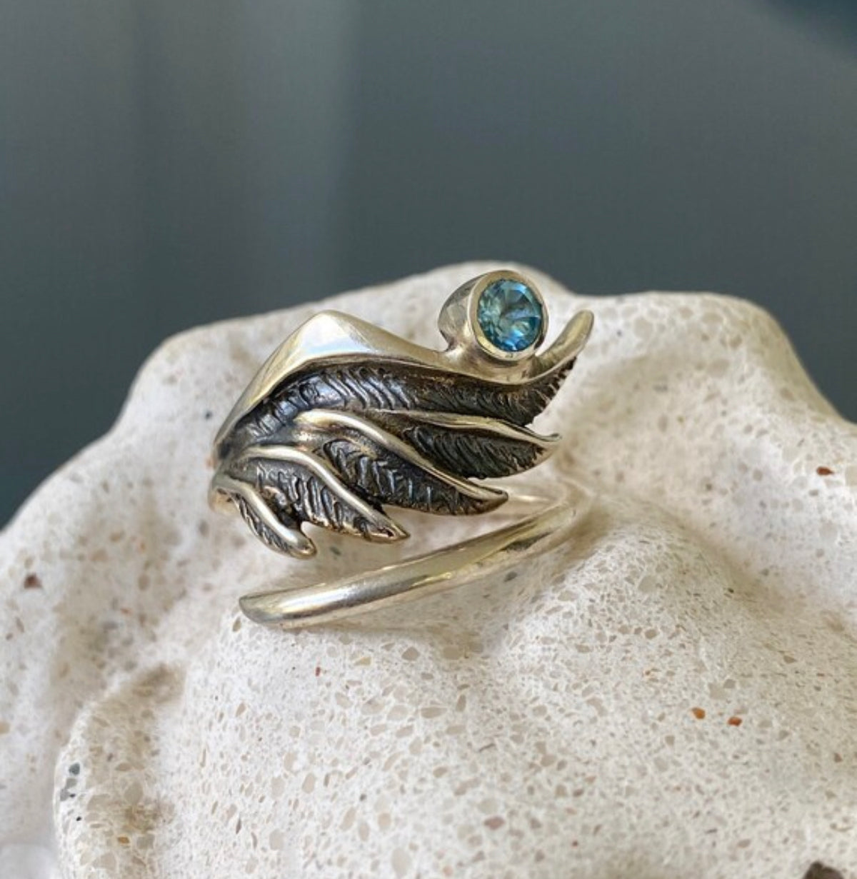 silver angel wing with a blue topaz