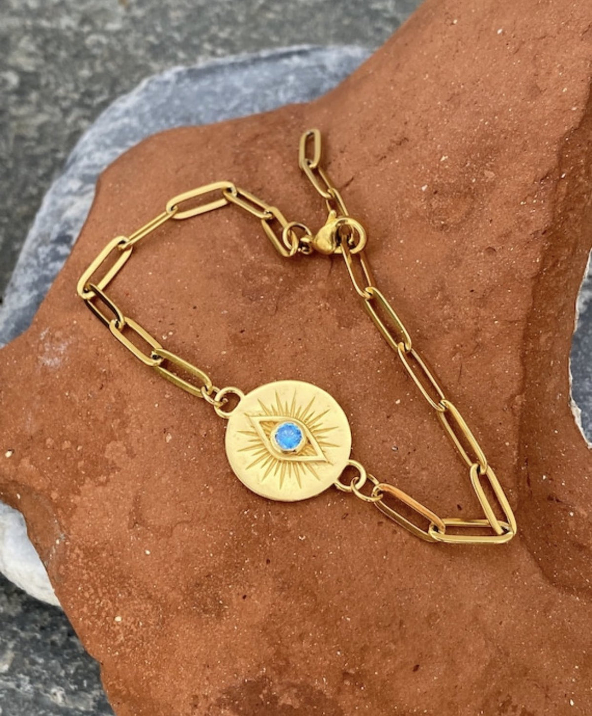 gold evil eye bracelet with a blue gemstone
