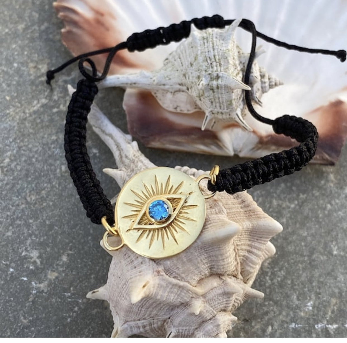 Evil eye bracelet gold with a blue gem, black macrame