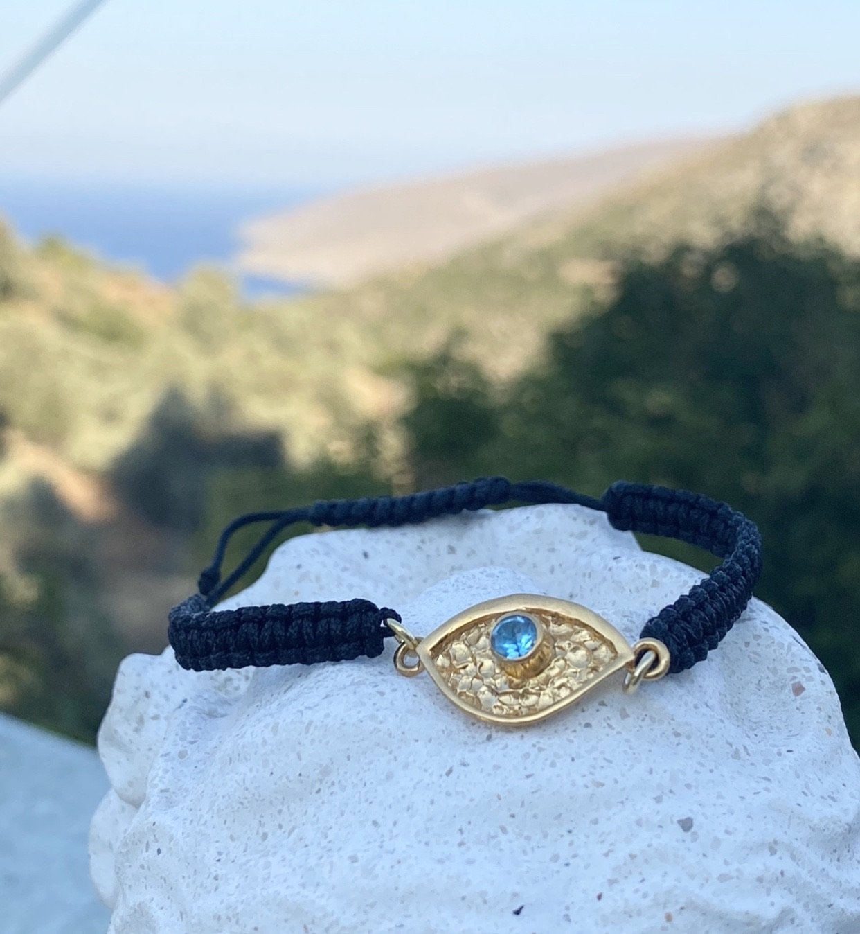 a gold evil eye handmade bracelet with a blue gemstone