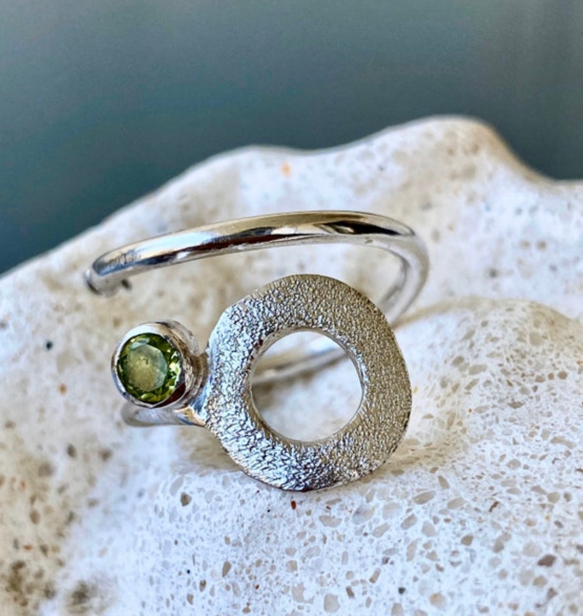 silver open circle ring with a peridot gemstone