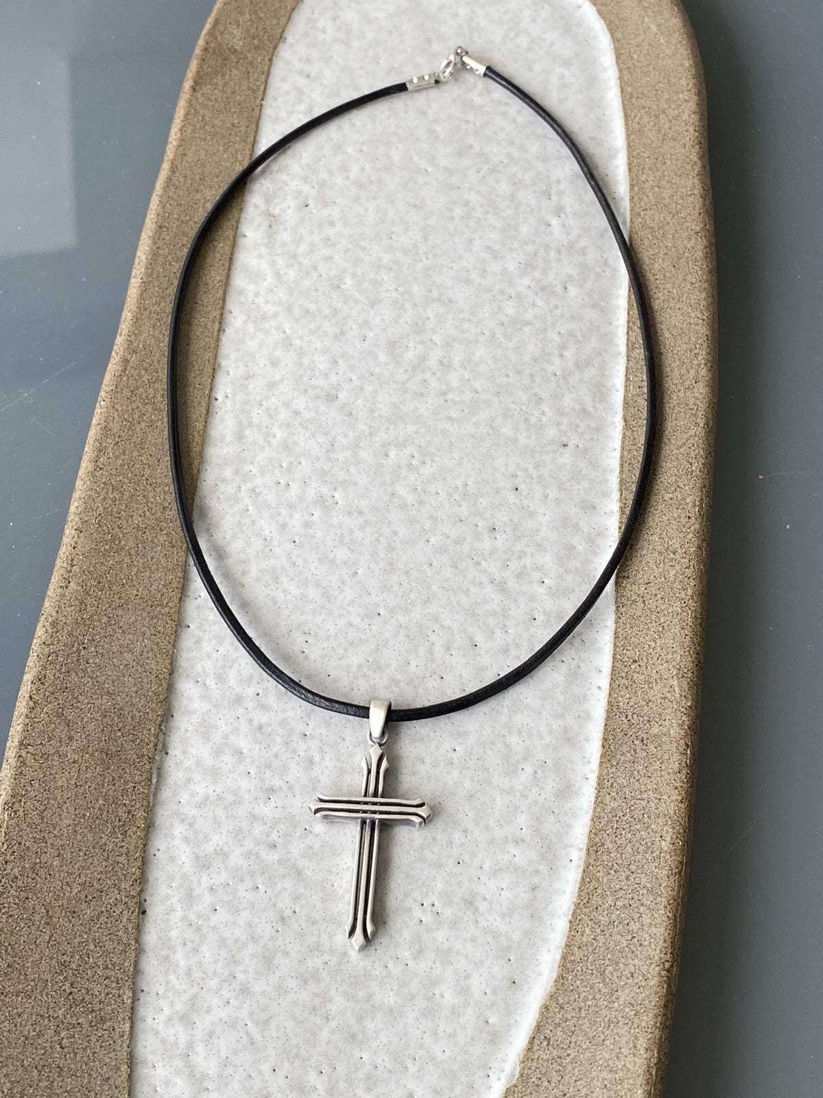 Silver cross necklace with a black leather cord 