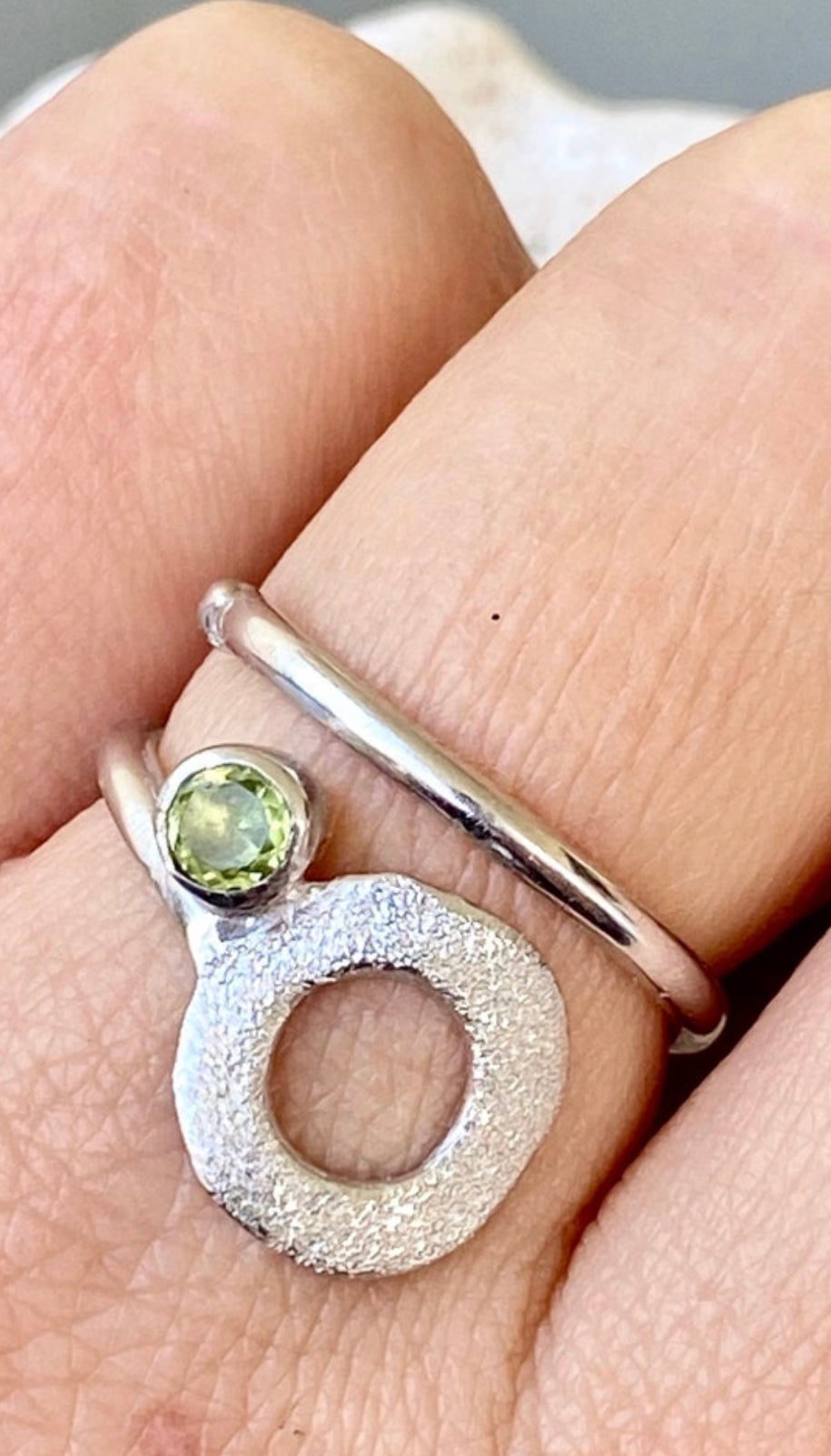 silver open circle ring with a peridot gemstone