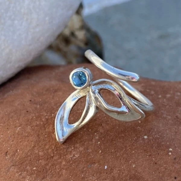 silver flower ring with blue gemstone