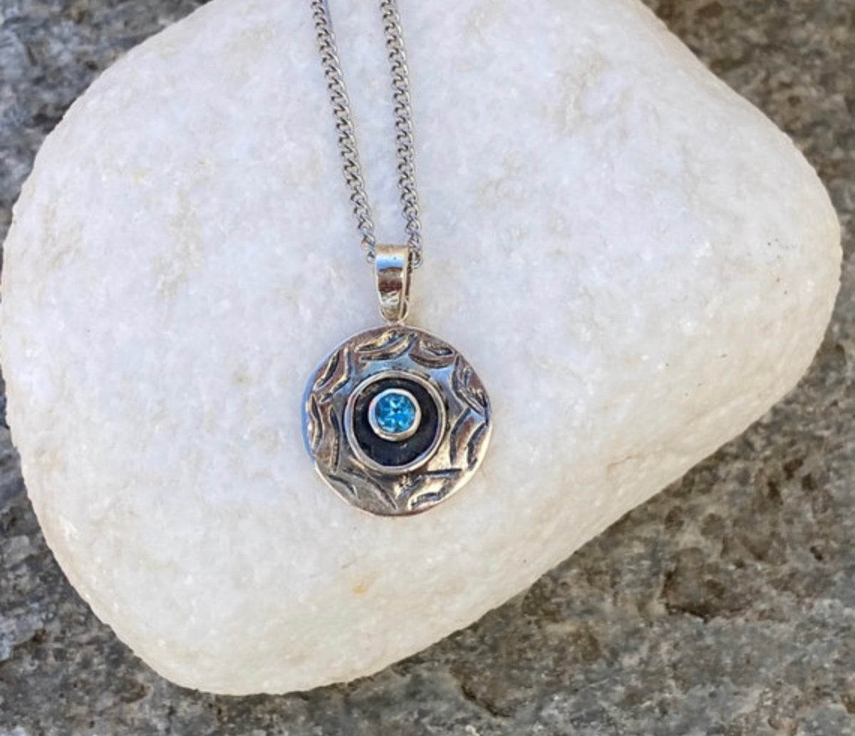 round evil eye necklace with blue topaz