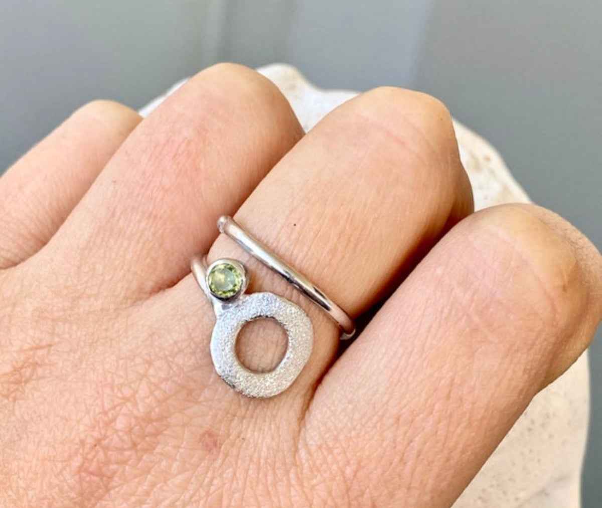 silver open circle ring with a peridot gemstone
