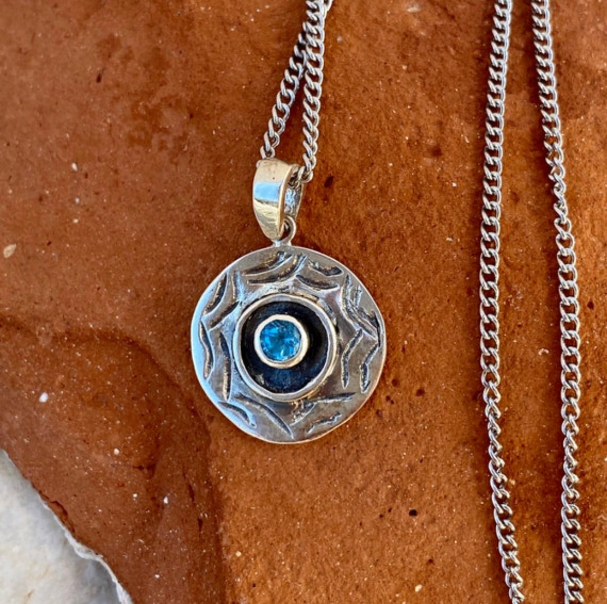 round evil eye necklace with blue topaz