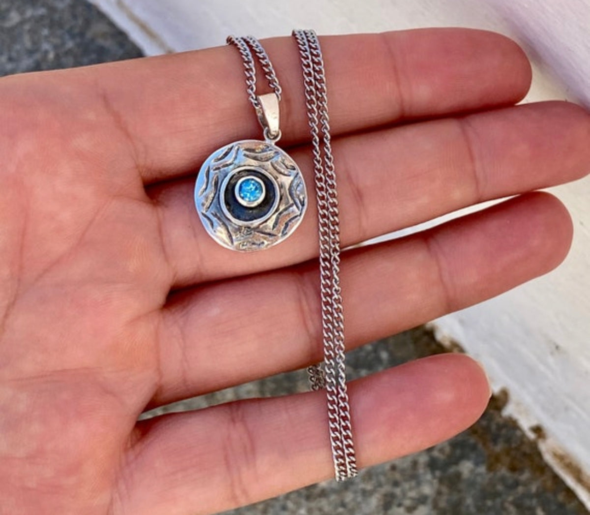 round evil eye necklace with blue topaz